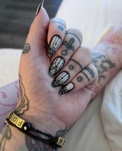a woman's hand shows gothic cathedral-style press-on fake fingernails