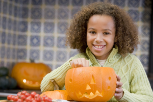 girl carving pumpkin on Halloween
