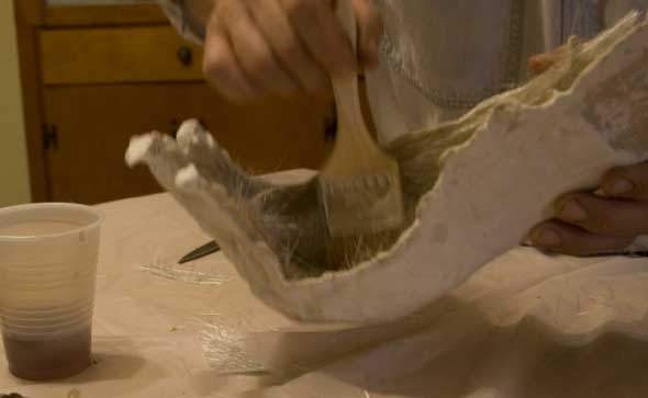 A hand painting a Halloween prop