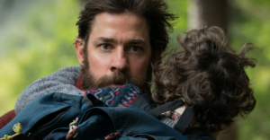 father carrying son and running in A Quiet Place movie