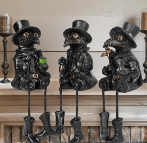 three Halloween plague crows sit on a fireplace mantel