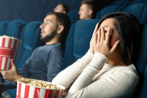 scared man and woman in a movie theater