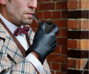 A man dressed as Sherlock Holmes smokes a pipe