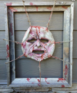 a scary Halloween skinned face is displayed on a door