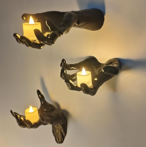 three decorative Halloween hands hold candles