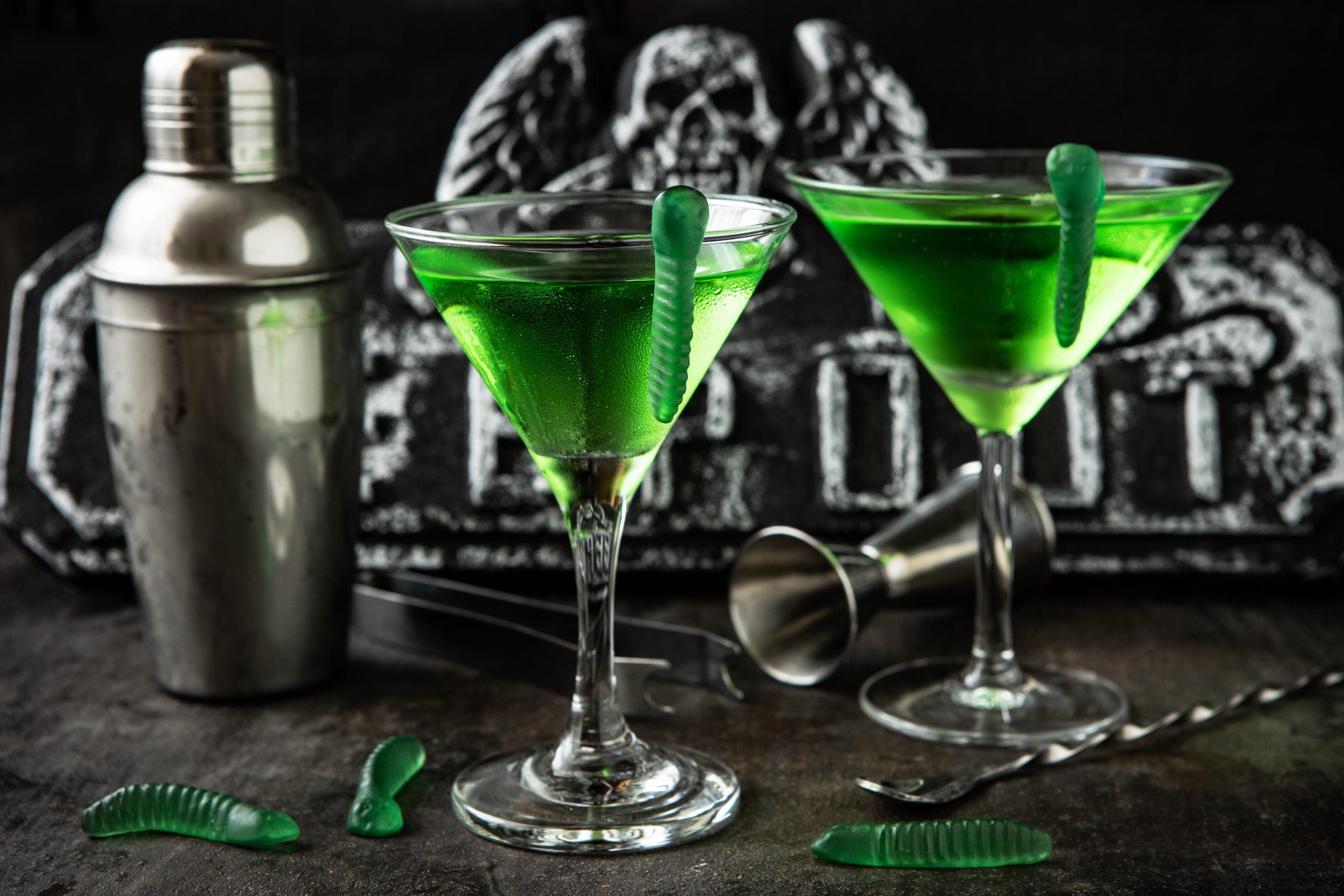 Two Halloween martinis contain green liquid and gummy worms