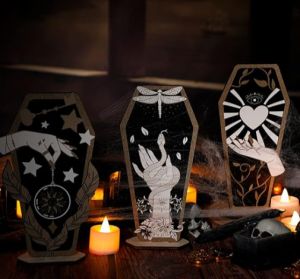 three decorative Halloween tombstones sit on a table